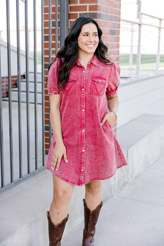 Woman with dark hair wearing a short-sleeve maroon denim midi dress.