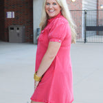 Woman with blonde hair standing in a side profile position wearing a midi red denim dress. 