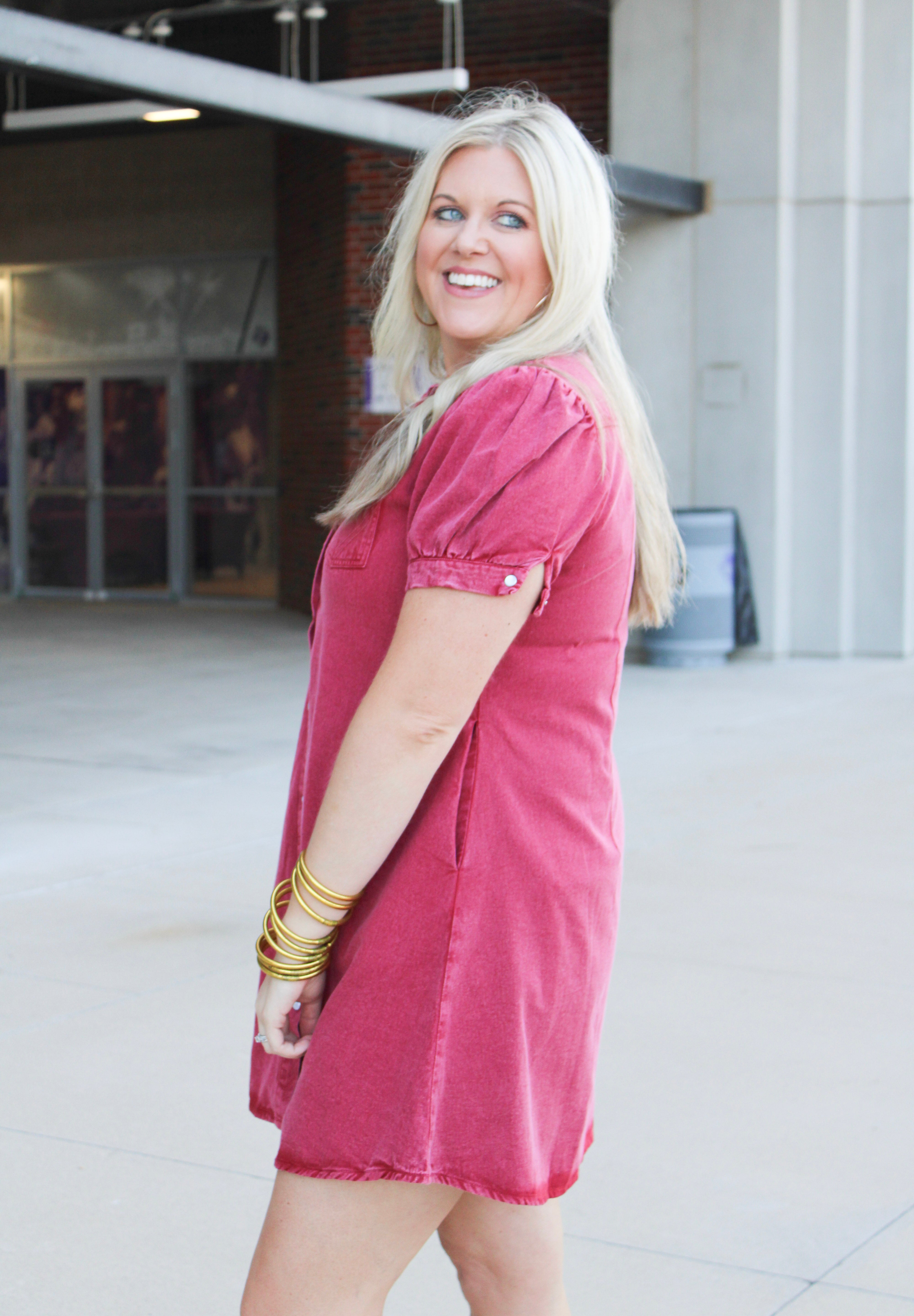 Woman with blonde hair wearing a short-sleeve maroon denim midi dress.
