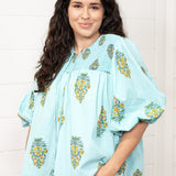 Woman with dark hair standing in a front profile position wearing the Ava Top against a white background. The focal point of this image is to see all aspects of the top. The model paired this top with dark-wash denim jeans. 