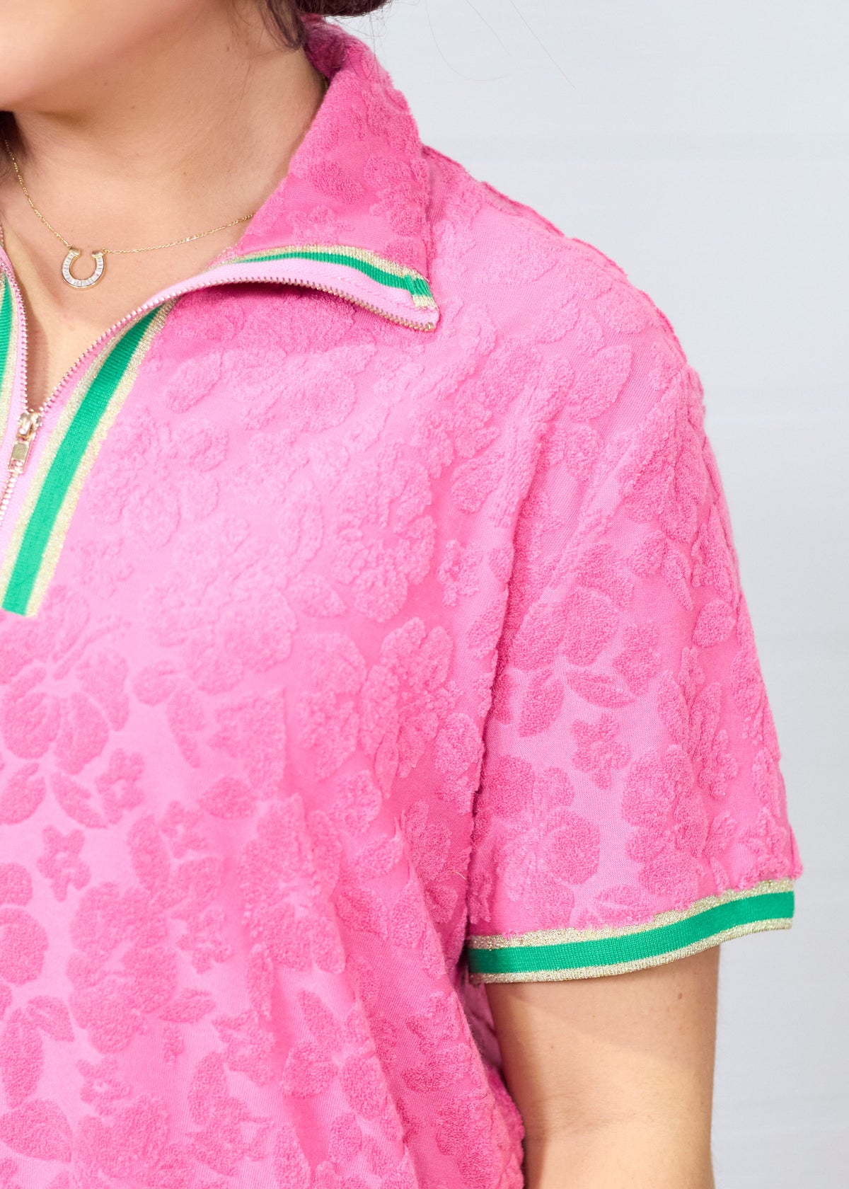 Woman with dark hair standing in a front profile position wearing the Cami Dress against a white background. The focal point of this image is an in-depth view of fabric print as well as a sneak-peak of the quarter zip on front of dress.