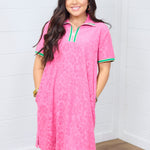 Woman with dark hair standing in a front profile position wearing the Cami Dress against a white background. The focal point of this image is the striping along cuff and quarter zip as well as dress length and fabric pattern.