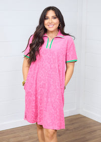 Woman with dark hair standing in a front profile position wearing the Cami Dress against a white background. The focal point of this image is the striping along cuff and quarter zip as well as dress length and fabric pattern.