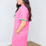 Woman with dark hair standing in a side profile position wearing the Cami Dress against a white background. The focal point of this image is the length of dress as well as showing off pockets. 