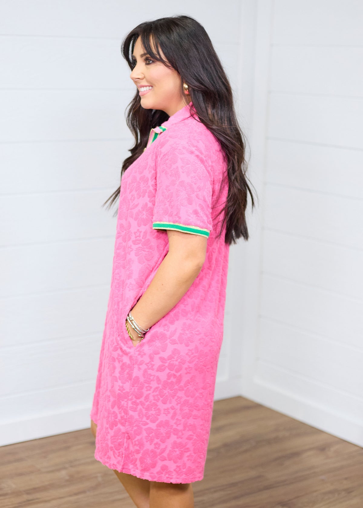 Woman with dark hair standing in a side profile position wearing the Cami Dress against a white background. The focal point of this image is the length of dress as well as showing off pockets. 