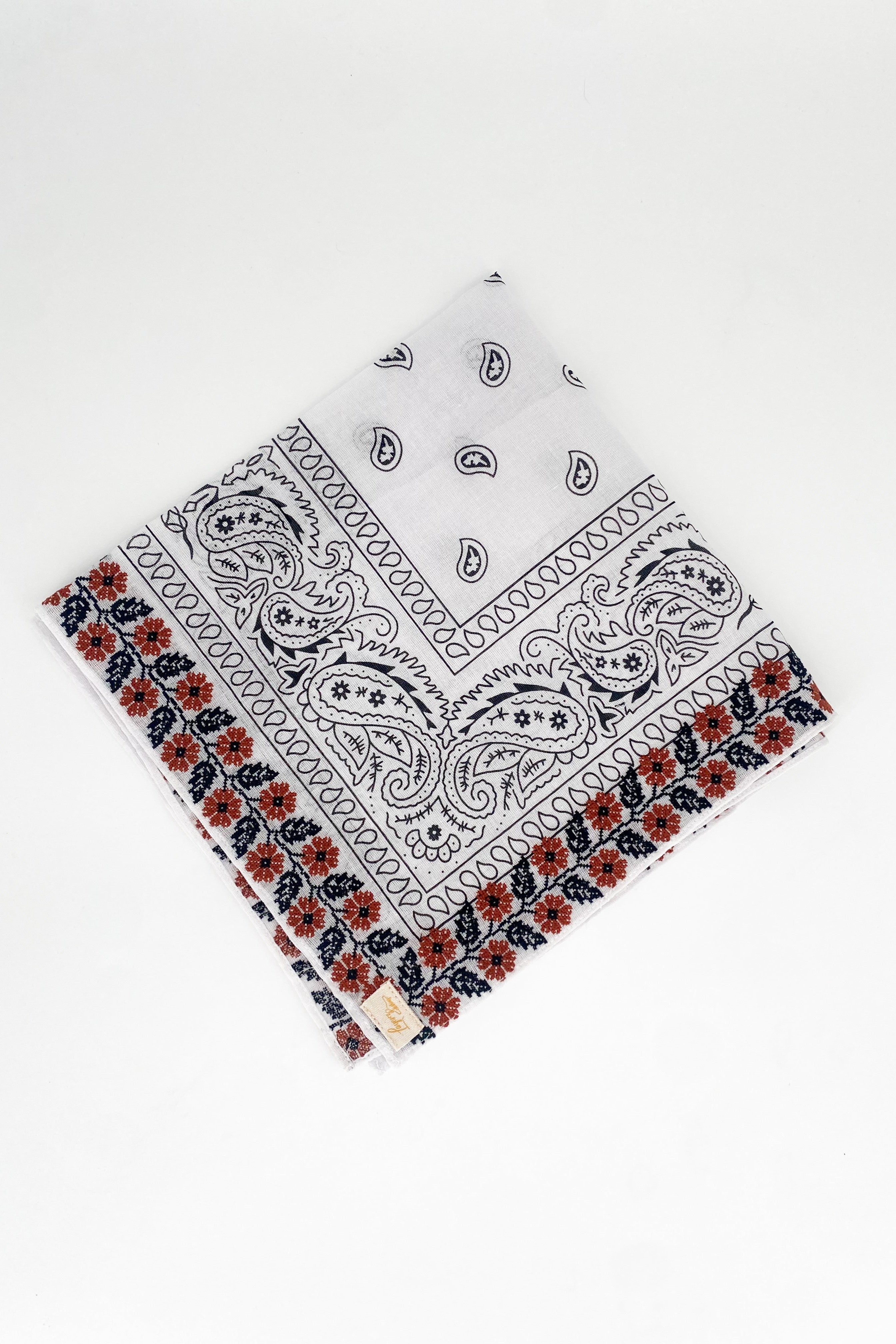 Zoomed out image of the burnt orange floral frilly. Floral pattern is embroidered. 