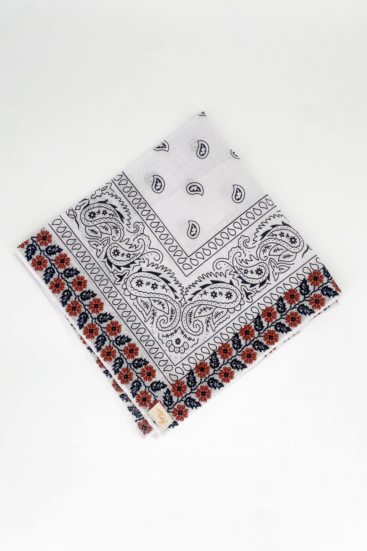 Zoomed out image of the burnt orange floral frilly. Floral pattern is embroidered. 
