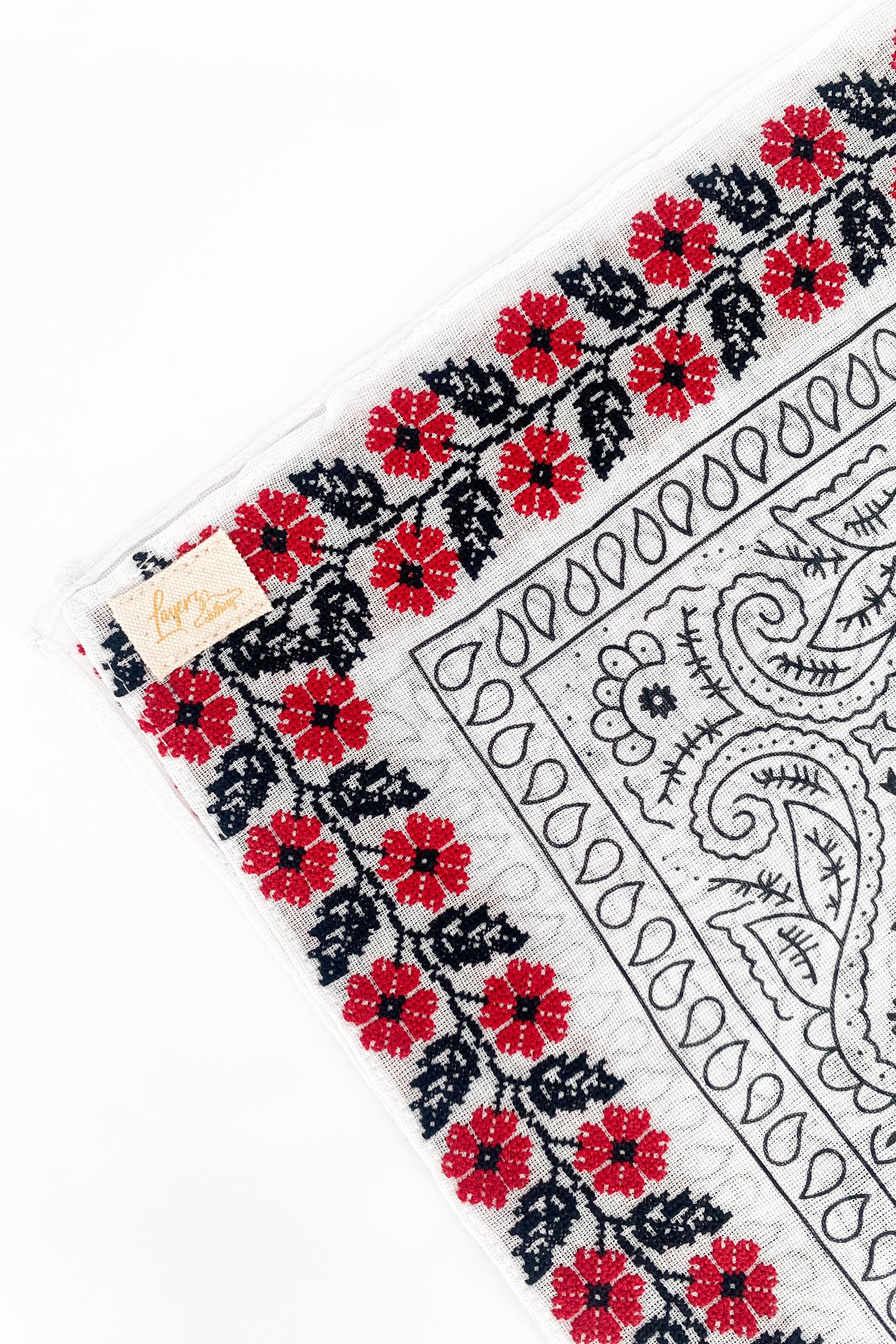 Zoomed in version of floral red frilly. Emphasis on the red floral embroidery. 