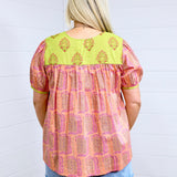 Woman with blonde hair showing back image of Jeanie top, paired with denim skirt. 