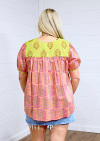 Woman with blonde hair showing back image of Jeanie top, paired with denim skirt. 