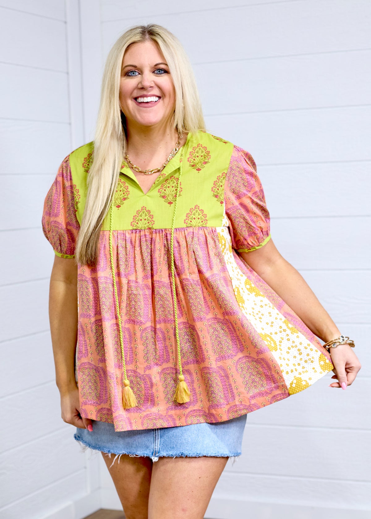 Woman with blonde hair standing in a front profile against white background. She paired the Jeanie Top with a denim skirt. 