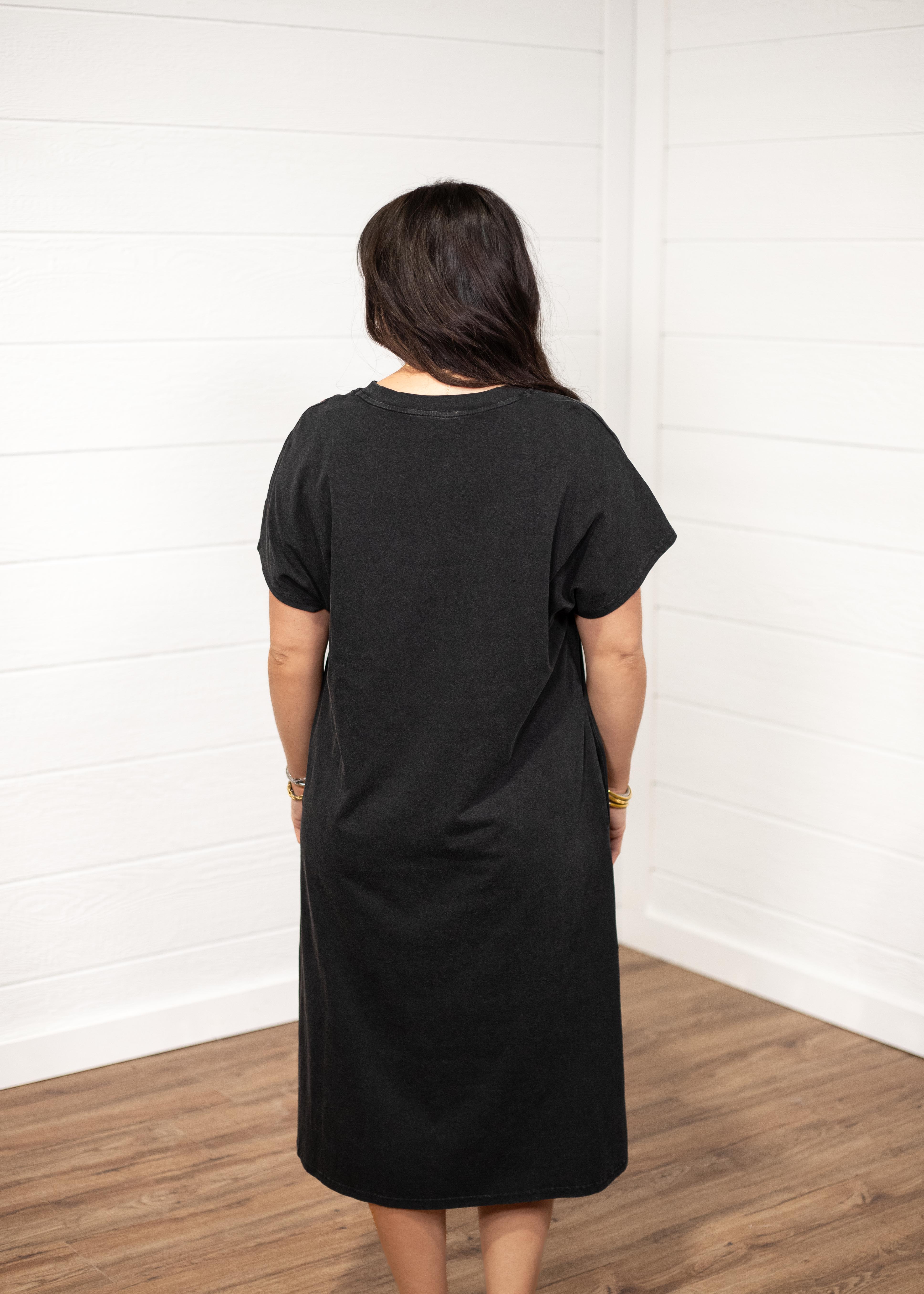 Woman with dark hair in a back facing position wearing the Jo Dress against a white background. The focal point of this image is the back of the dress with emphasis on it's length and color. 