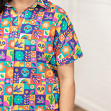Woman with dark hair standing in a front profile position with a deep focal length allowing better perception of graphics. The model is wearing the Lindsey dress with a white background. The focal point of this image is the graphics on the front and sleeve of dress. 