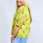 Woman with blonde hair shows side profile of the Margo Top with a white background. She has the top paired with a light-wash denim skirt.