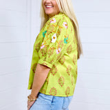 Woman with blonde hair shows side profile of the Margo Top with a white background. She has the top paired with a light-wash denim skirt.