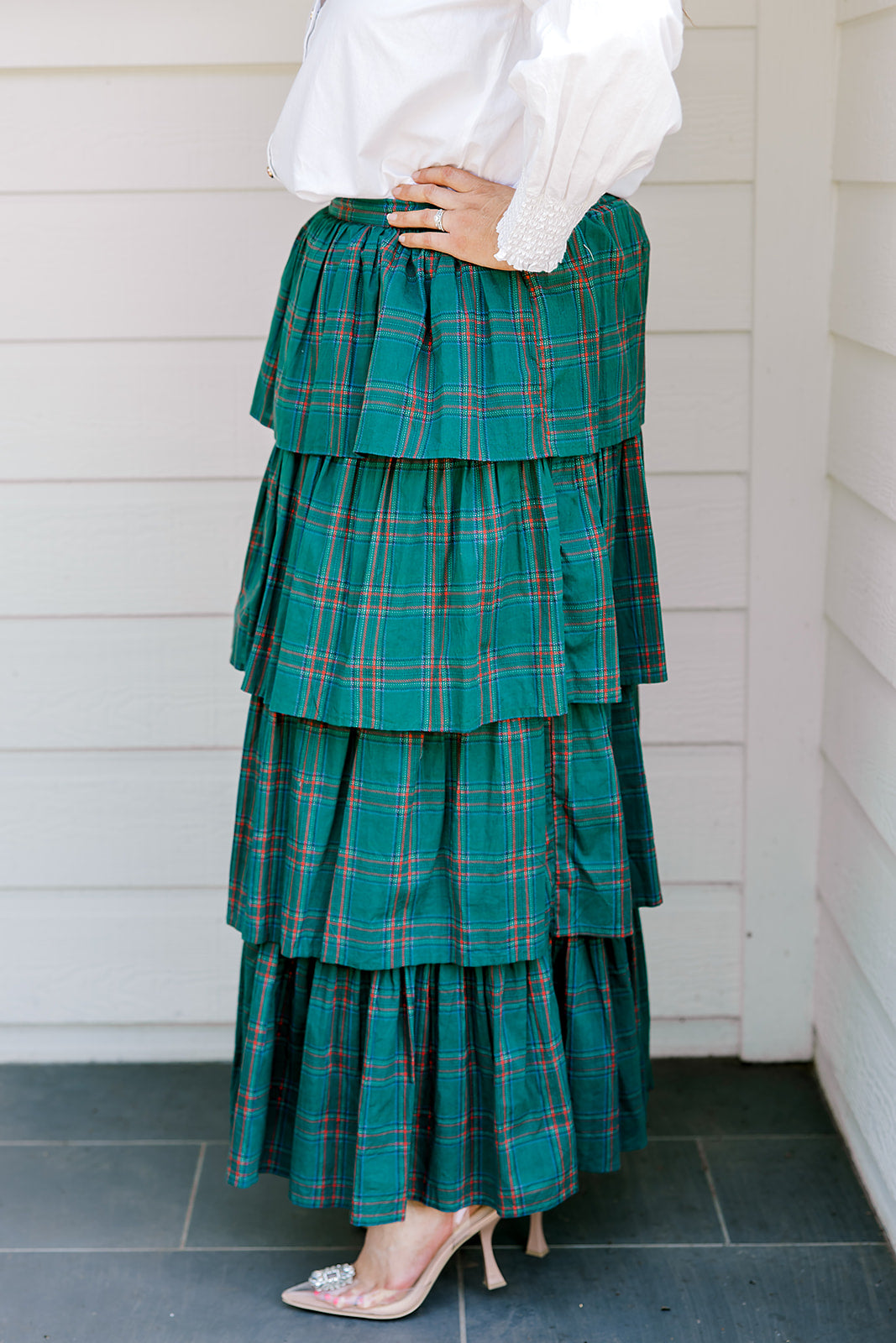 Woman wearing a green/red plaid maxi ruffle skirt with the Renee Top-White. 