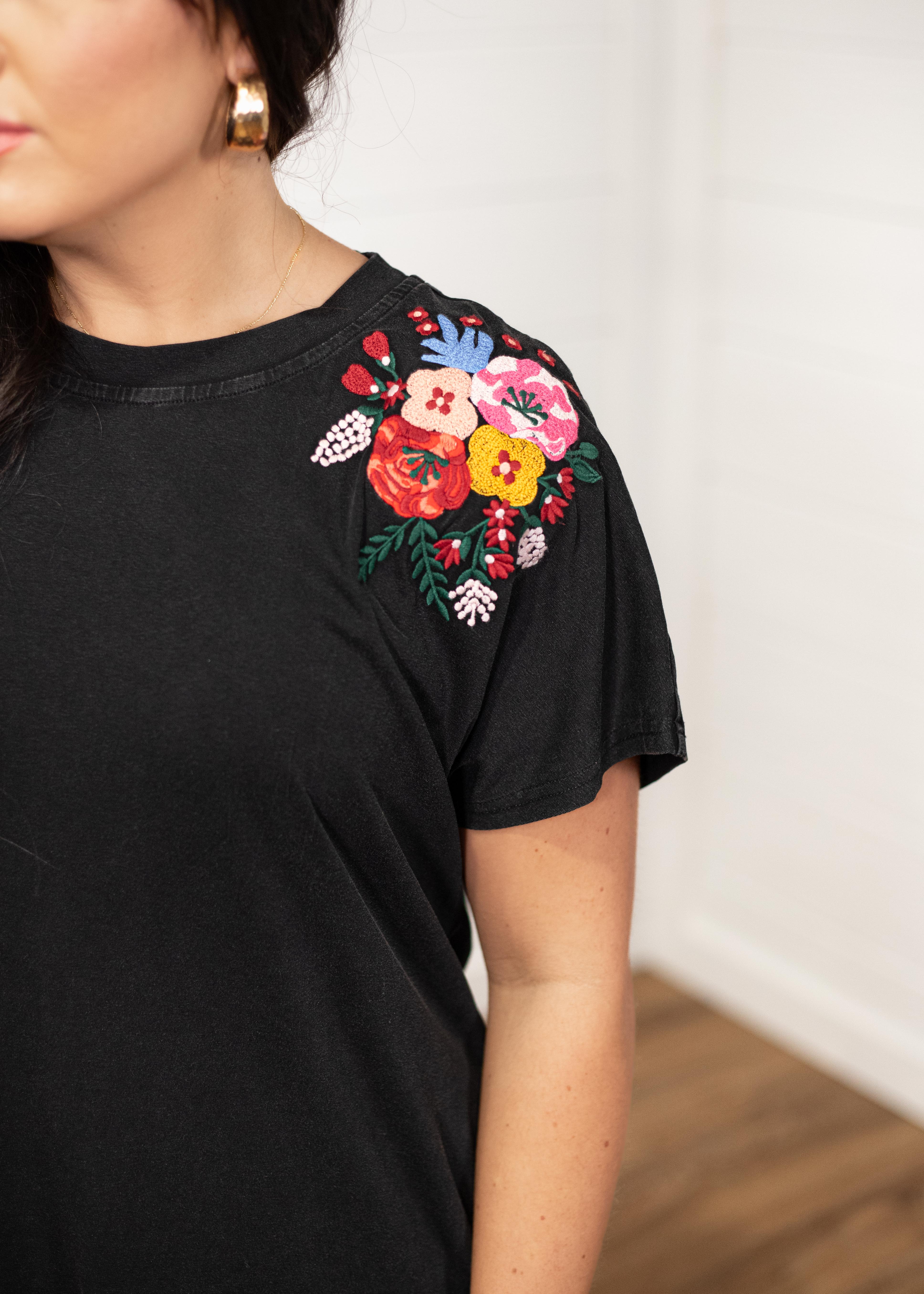 Woman with dark hair in a front facing position wearing the Jo Dress with a deep focal length. The focal point of this image is the shoulder region with emphasis on the embroidery on the sleeves. 
