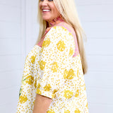 Woman with blonde hair in a side profile position showing the side graphics of the Tinley Top. She has this top paired with light-wash denim and is against a white background. 
