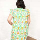 Woman with dark hair standing in a back profile position wearing the Wren Dress against a white background. The focal point of this image is to show the graphic on the back of the dress as well as show the length of the dress. 